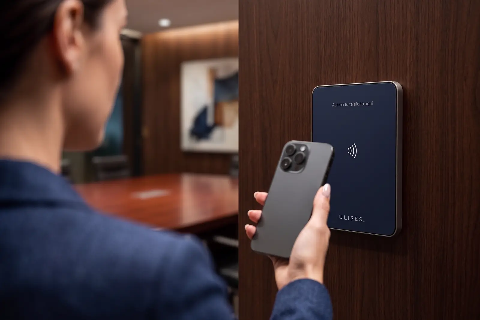 Mano acercando el celular a la placa NFC de la pared.